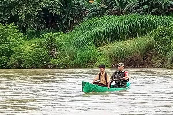 Babinsa Koramil 1405-08/Tanete Riaja Serka Amir mendayung perahu ditengah banjir untuk mengantar anak bersekolah