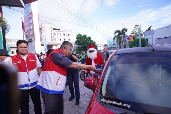Santa Claus membagikan bingkisan Natal kepada pelanggan SPBU di Manado